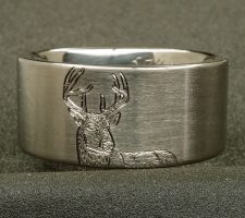 Ring depicting a deer and tree with the couple's initial's carved in it