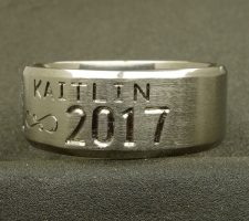 A titanium wedding ring with the name Kaitlin designed by Dave Kessner.