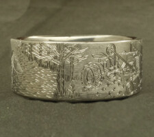 Ring depicting a duck and a tractor in a field
