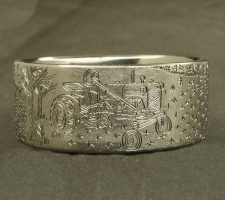 Ring depicting a duck and a tractor in a field