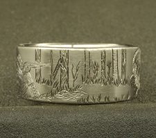 A ring depicting a hunter aiming his gun at a turkey