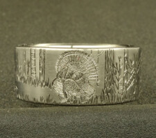 A ring depicting a hunter aiming his gun at a turkey