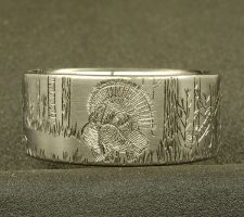 A ring depicting a hunter aiming his gun at a turkey