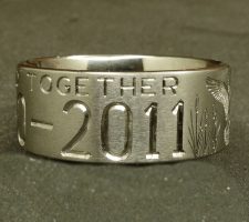 Two line titanium duck ring with committed pair of mallards and cattails. With a crossed shotgun and fishing pole with family initials