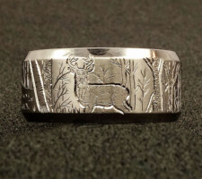 A titanium wedding band with a deer on it designed by Dave Kessner.