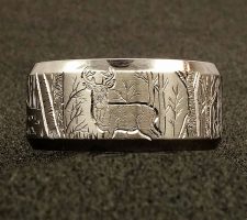A titanium wedding band with a deer on it designed by Dave Kessner.