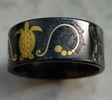 Inlayed gold turtle with a black zirconium band