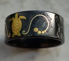 Inlayed gold turtle with a black zirconium band