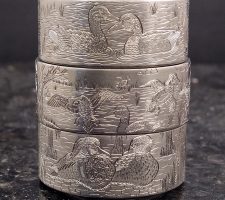 Three stacked rings depicting waterfowl and wildlife