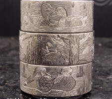 Three stacked rings depicting waterfowl and wildlife