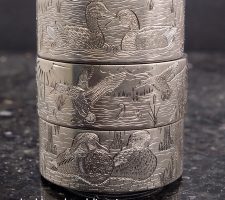 Three stacked rings depicting waterfowl and wildlife