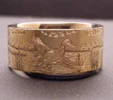 Gold A yellow gold duck band wedding ring with a flying duck by Dave Kessner.