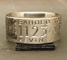 Titanium duck ring showing part of an engraved wedding date and the word together